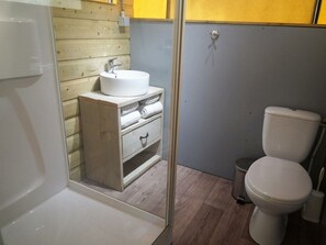 Ein Badezimmer mit Waschbecken, Holzschrank und Toilette.