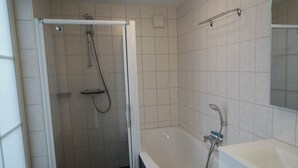 Une salle de bain équipée d’une douche, d’une baignoire et d’un lavabo.