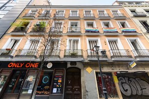 Ein mehrstöckiges Gebäude mit einer Schaufensterfront mit der Aufschrift 'ONLY ONE' und einem geschlossenen Geschäft mit dem Schild 'Café'.