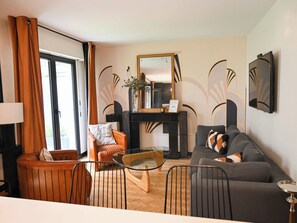 A modern living room with a sofa, armchairs, a glass coffee table, and a fireplace. - Nice 85 M² Decorated With Nice Terrace With Trees (Paris)