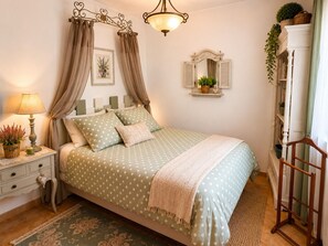 Ein ordentlich eingerichtetes Schlafzimmer mit Bett, Nachttisch, Lampe und Spiegel.