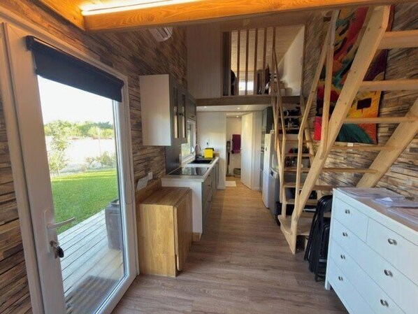 A narrow hallway with a wooden floor, a staircase, and a door leading outside. - Chalet with garden and terrace in Saint-Xandre (Saint-Xandre)