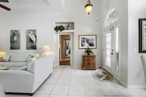 A modern living room with a sofa, a lamp, and wall art. - Private Pool, Wifi, Outdoor Lounger, Family Fun (Rotonda West)