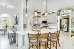 A spacious kitchen with a large island, pendant lights, and a ceiling fan. - Private Pool, Wifi, Outdoor Lounger, Family Fun (Rotonda West)