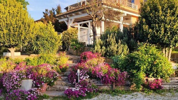 A house with a garden, steps leading to the entrance, and a balcony. - Joka B&B (Potenza Picena)