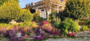 Una casa con jardín, escalones que llevan a la entrada y un balcón.