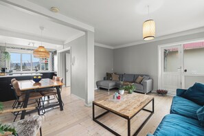 Ein moderner Wohnbereich mit Essplatz, einer Couch und einem Couchtisch.
