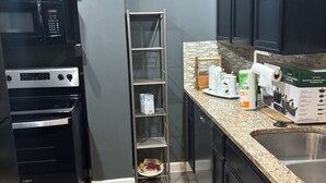 Cocina compacta con microondas, horno y pileta de acero inoxidable.
