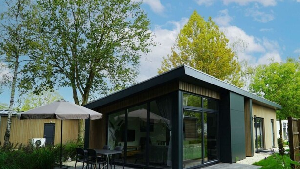 A modern house with a patio, a dining area, and a covered outdoor seating area. - Pavilion Maximaal 4 (Kaatsheuvel)