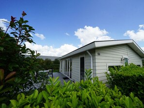 Ein Bungalow mit Garage, umgeben von üppiger Vegetation und blauem Himmel.