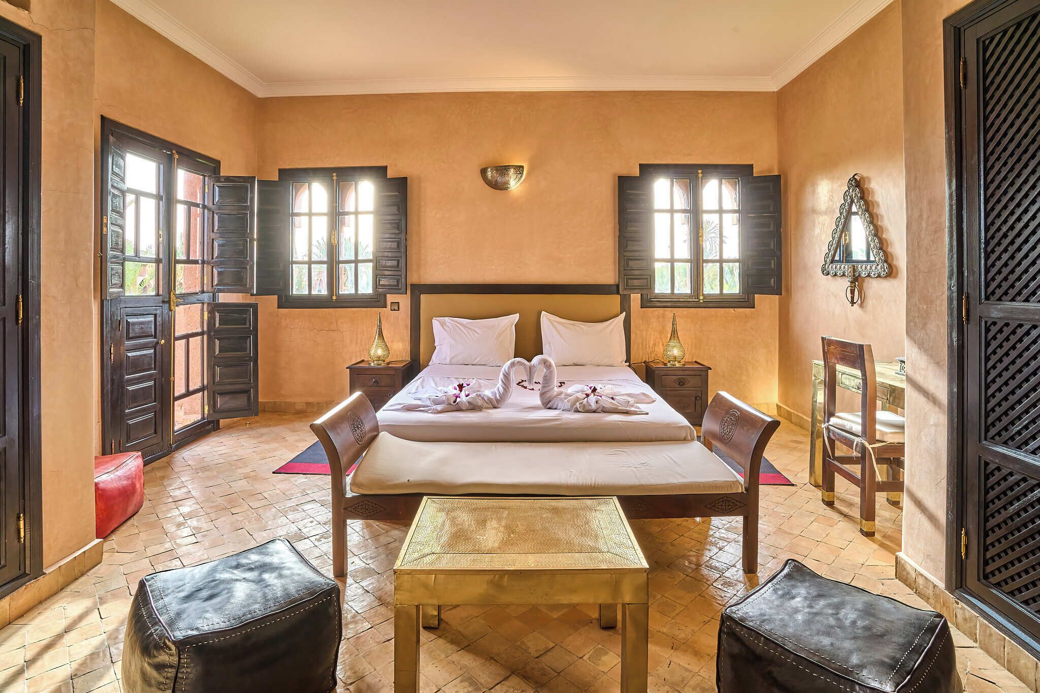 A bedroom with a bed, two nightstands, a bench, and a chair.