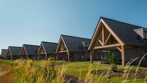 A row of modern, single-story buildings with pitched roofs, likely part of a resort or hotel. - Villa in Cadzand With Terrace and Wi-fi (Cadzand-Bad)