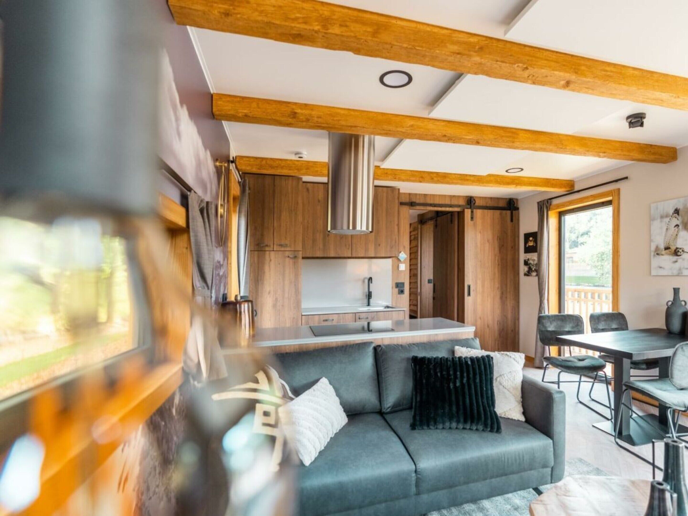 Ein modernes Interieur mit einer Couch, einem Esstisch und einer Küchenzeile.