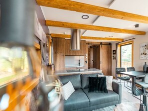 Ein modernes Interieur mit einer Couch, einem Esstisch und einer Küchenzeile.
