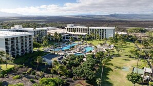 A hotel with multiple buildings, a swimming pool area, and a view of distant mountains. - Marriott Waikoloa Ocean Club resort in Waikoloa Village with AC and OCEAN VIEW (Waikoloa Village)