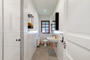 Une petite salle de bain comprenant des toilettes, un lavabo et un miroir.