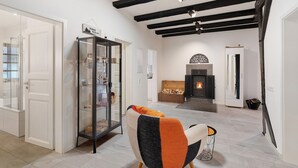 A modern interior with exposed beams, a fireplace, and a glass display cabinet. - Apartment 'Ferienwohnung Höflelounge' with Mountain View, Balcony and Wi-Fi (Oppenau)