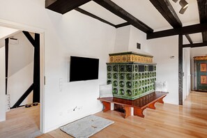 Ein Zimmer mit einer hölzernen Bank, einem Fernseher und einer Wand mit grünen Wandplatten.