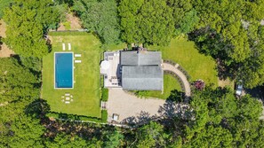 An aerial view of a property with a swimming pool, a covered patio, and a large house. - Completely Renovated Modern Hampton Bays Retreat with Brand New Pool,... (Hampton Bays)