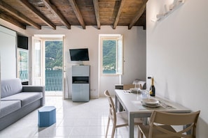 Ein modernes Zimmer mit Sofa, Esstisch und Fernseher.