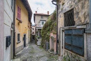 Ein schmaler Kopfsteinpflastergang mit Häusern an beiden Seiten, der traditionelle Architektur und eine rustikale Atmosphäre zeigt.