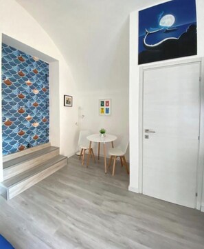 A hallway with a staircase, a dining area with a table and chairs, and a door. - Just a short walk from the subway and near the historic center of Naples (Napoli)