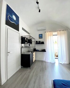 A compact room with a desk, a chair, a bed, a window with curtains, and a painting on the wall. - Just a short walk from the subway and near the historic center of Naples (Napoli)