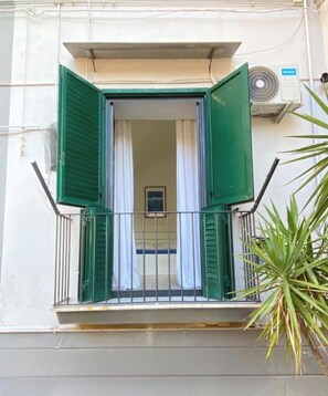 A balcony with green shutters, a white curtain, and a small window. - Just a short walk from the subway and near the historic center of Naples (Napoli)