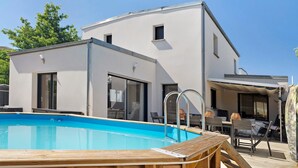 A modern house with a swimming pool, large windows, and a patio area. - 4-Bedroom Villa with Private Pool & Spa for 8, Carquefou/Nantes (Carquefou)