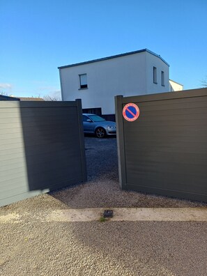 Ein begrenzter Zugangsweg führt zu einem Gebäude, an dem ein Verbotsschild für Parken angebracht ist.