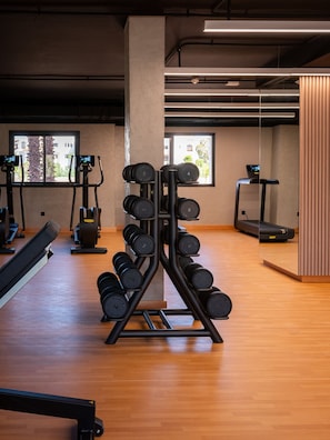 A gym with a weight rack, treadmills, and a mirror.