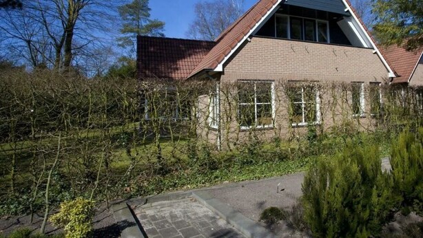 A house with a sloped roof, brick walls, and a window. - Groepsaccommodatie 18 Otterlo (Otterlo)