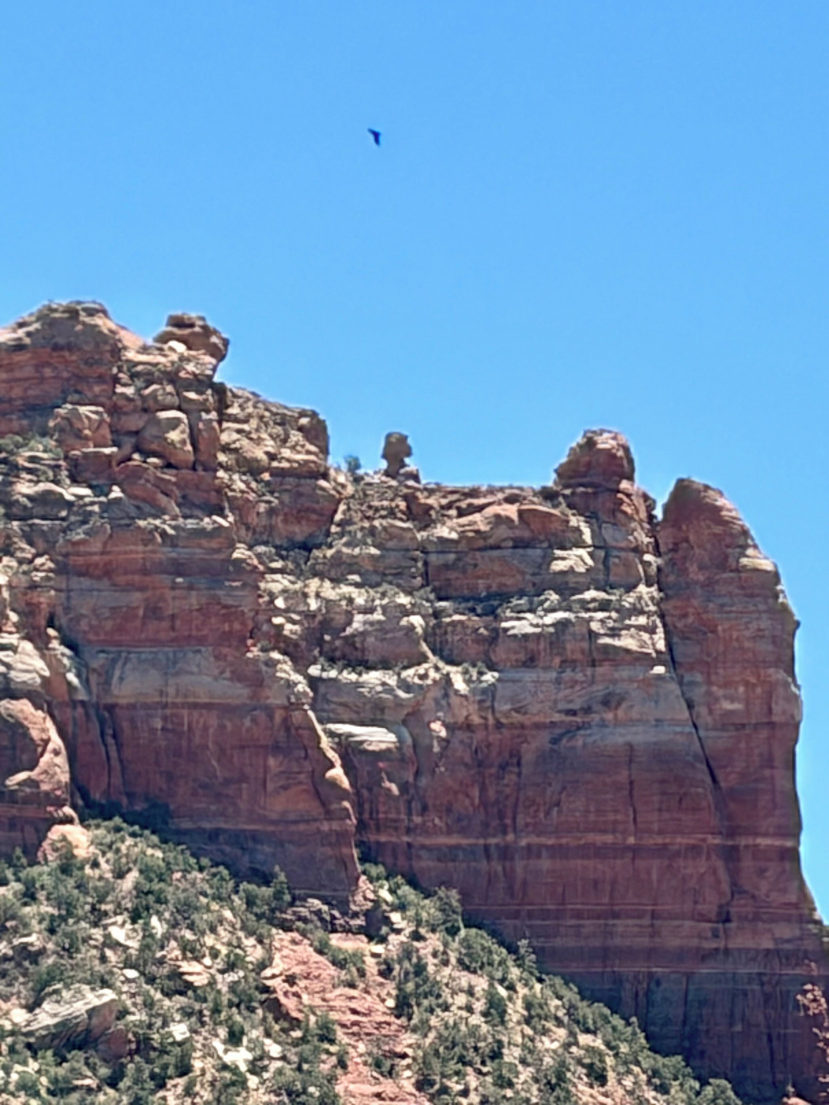 A large rock formation with a clear sky.