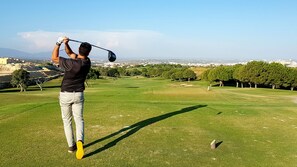 Ein Golfplatz mit freiem Blick auf die Skyline im Hintergrund.