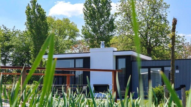 A modern building with large windows, surrounded by greenery. - Cube Exclusive 6 (Nieuwvliet)