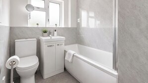 Une salle de bain avec des toilettes, un lavabo et une baignoire.