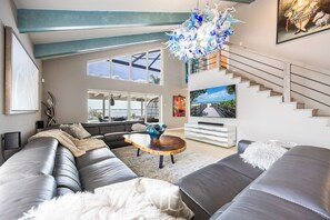 Un salon moderne avec un canapé, une table basse et un escalier.