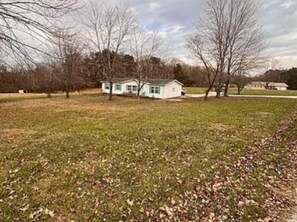 A house with a lawn and trees in the background. - Reindeer Crossing - Prancer Blue - 1.5 mi to HW (Dale)