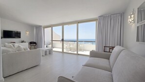 A modern living room with a sofa, a coffee table, and a TV on the wall. - Sunset View Albufeira 53 (Albufeira)
