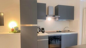Een moderne keuken met grijze kastjes, een inbouwoven en een spoelbak.