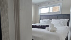 Habitació d'hotel amb un llit, una finestra i una cortina.