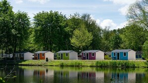 A row of small, colorful cabins by a calm lake, surrounded by trees. - Holiday Home in Amstelveen With Terrace (Amstelveen)