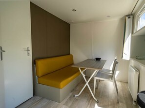 Een knus ingerichte kamer met een bank, een tafel en een stoel.