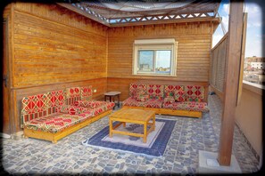 A wooden room with two sofas, a small table, and a window. - Spacious 2-bedroom apartment with Rooftop between GEM and Giza Pyramids (Giza Governorate)