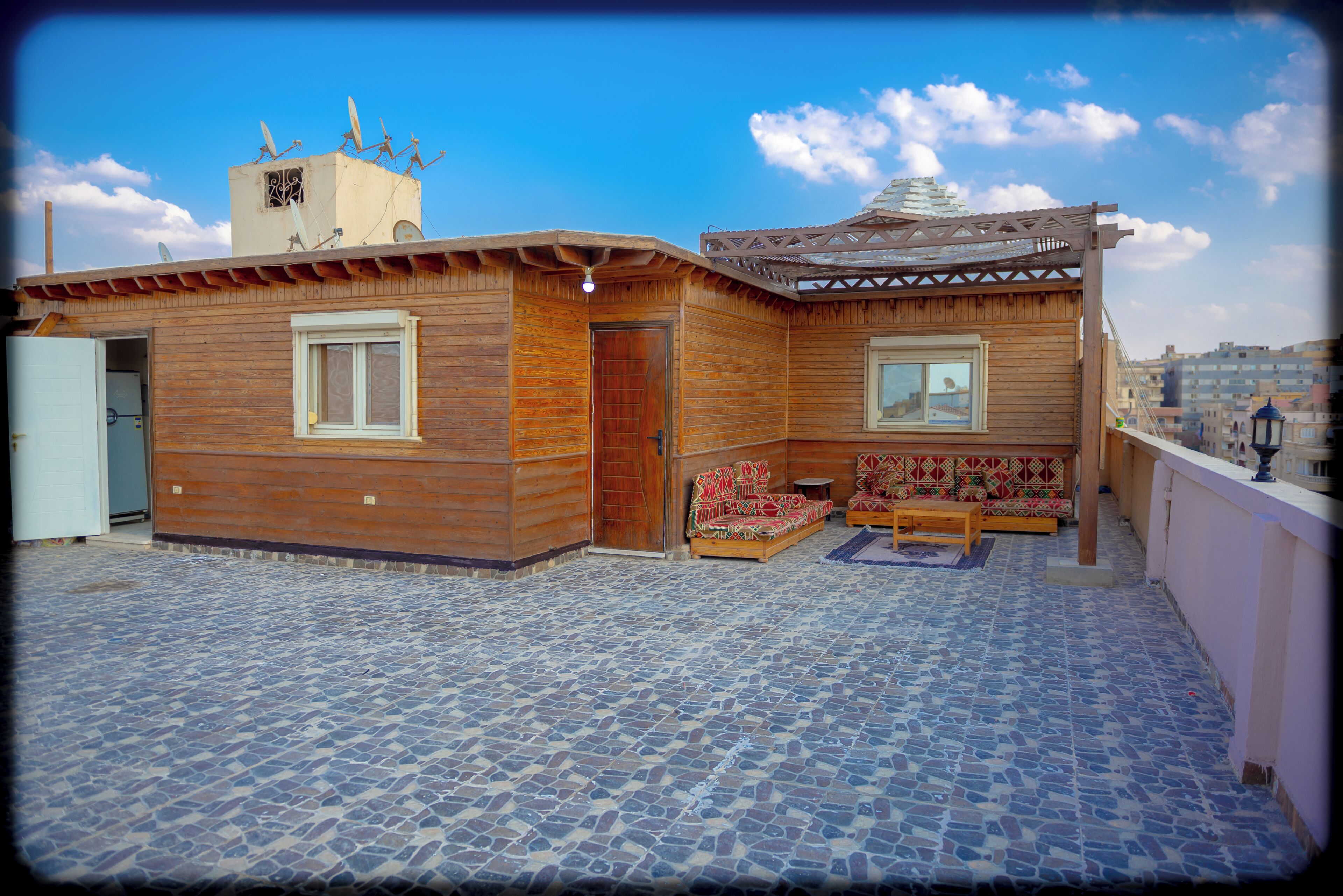 A wooden building with a balcony, a door, and a window.