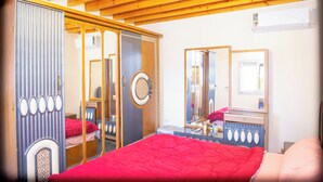A bedroom with a bed, a dresser, a mirror, and a ceiling fan. - Spacious 2-bedroom apartment with Rooftop between GEM and Giza Pyramids (Giza Governorate)