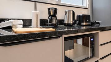 A modern kitchen with a built-in oven, a coffee maker, and a toaster on the countertop.