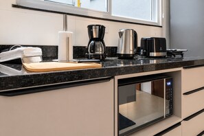 A modern kitchen with a built-in oven, a coffee maker, and a toaster on the countertop.