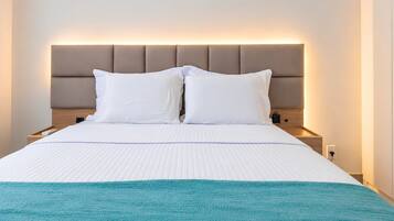 A hotel room with a bed, a headboard, a nightstand, and a bedside table.