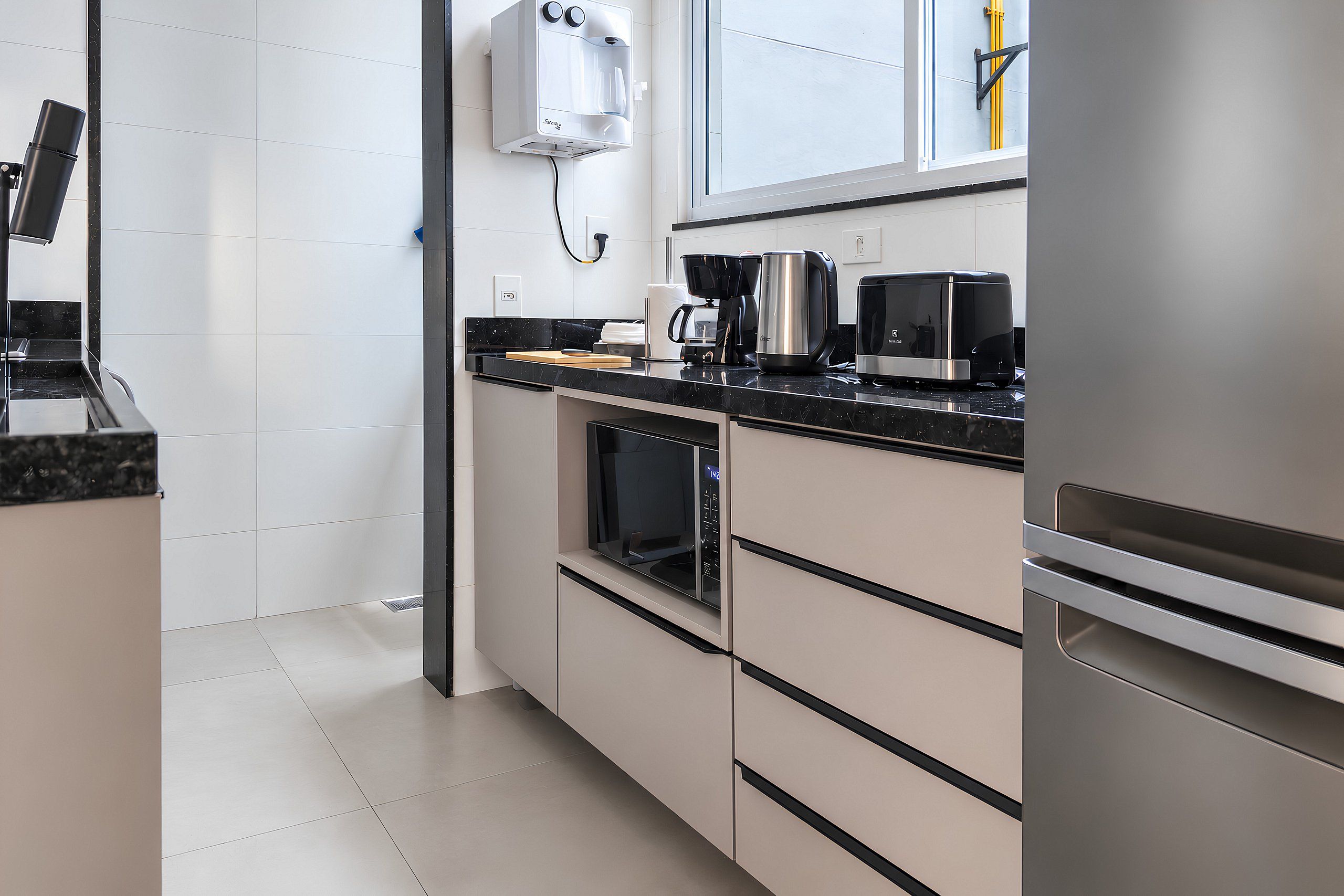 A modern kitchen with a built-in oven, a coffee maker, and a microwave.